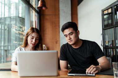 İki ciddi iş adamı iş yapmak için yeni bir plan üzerinde çalışırken dizüstü bilgisayar kullanıyor..