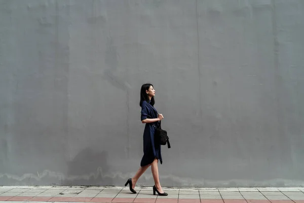 Gyönyörű Fiatal Ázsiai Kék Ruha Séta Járdán Gigantikus Beton Fal — Stock Fotó
