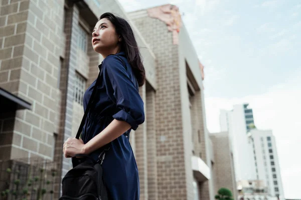 Arka Plan Mavi Elbiseli Güzel Asyalı Kadın Siyah Çanta Taşıyor — Stok fotoğraf