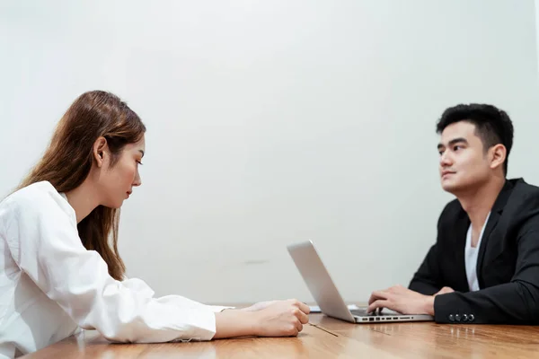 Asian boss doing an interview with a new girl in office room.