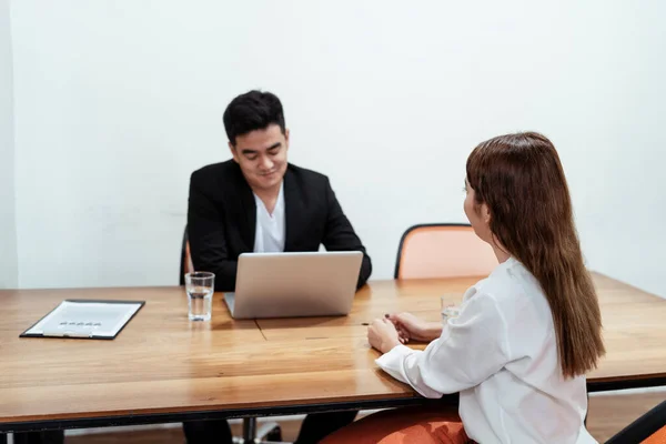 Asian boss happy to see new applicant sitting in the room ready for interview.