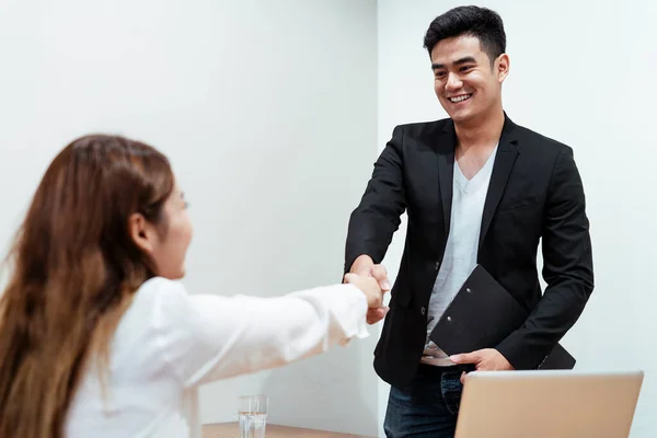 Şirketiyle çalıştıktan sonra yeni çalışanıyla tokalaşan neşeli iş patronu. Gülümse patron..