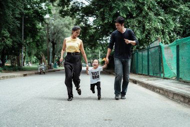 Mutlu bir aile parka doğru koşuyor. Keyifle evlerine gidiyorlar..