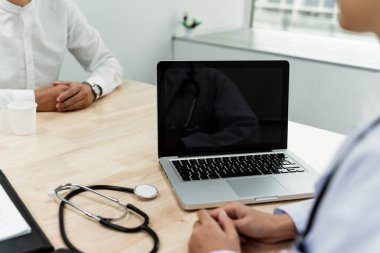 Doktor ve hasta sohbeti yaparken bilgisayar ve steteskop görüntülerini kestim..