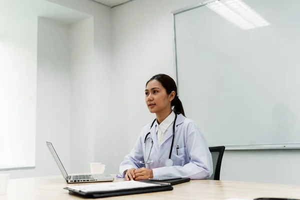 Female doctor sitting in consultation room with smart and cool.