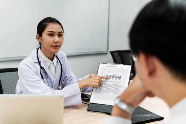 女医生向病人出示健康检查报告 并在报告中抱怨结果不好 — 图库照片