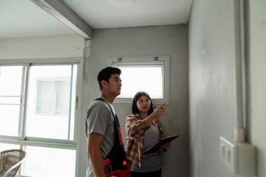 Tamirci ve patronu ne kadar güvenli olduğunu kontrol etmek için inşaat alanındaki duvarı kontrol ediyor..