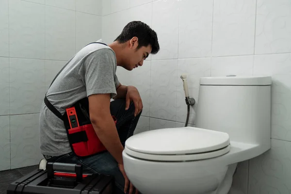 Tukang Pipa Duduk Dan Memeriksa Toilet Untuk Melihat Mana Itu — Stok Foto