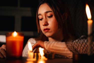 Uzun saçlı güzel bir kadın falcının karanlık odada portresi..