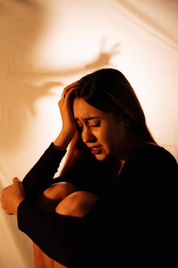 Güzel melez kadın hayalet ellerin arasında oturuyor..