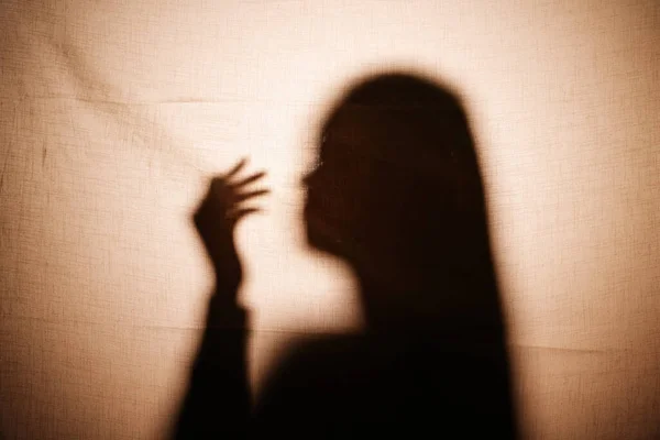 Shadow of horror. Long hair woman behind the wall. Mystery ghost.