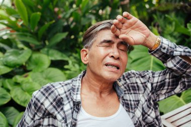 Çiftlikte çalışmaktan yorgun düşmüş Asyalı yaşlı çiftçinin portresi..