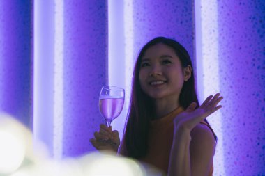 Güzel Asyalı Taylandlı kadın, gece kulübündeki insanlara merhaba demek için el sallıyor..