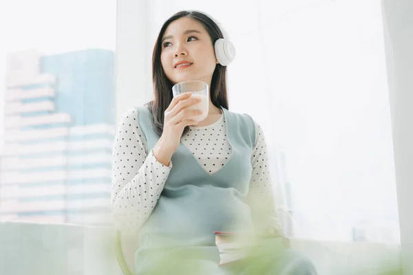 Ung Vacker Gravid Asiatisk Kvinna Bär Trådlös Hörlurar Hålla Kopp — Stockfoto