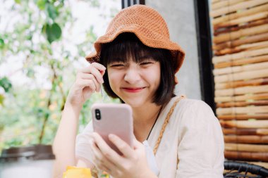 Güzel Asyalı Taylandlı kadın yemekten önce akıllı telefon ve pastayla selfie çekiyor. Sosyal medya blogcusu. Nüfuzlu. Gıda blogcusu veya vlogger.