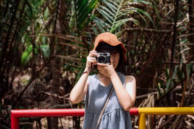 Genç Asyalı Taylandlı kadın gezgin, Country Side Road 'da klasik kameralı. Yerel gezi.