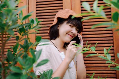 Güzel Asyalı Taylandlı kadın yerel bir pansiyonda akıllı telefon kullanıyor. Yerel gezi.