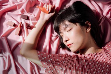 Üst Manzara - Güzel Asyalı Taylandlı kadın pembe arka planda kısa siyah saçlı kozmetik.