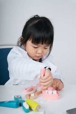 Güzel Asyalı Taylandlı çocuk dişçi oyuncağı rolünde oynuyor..