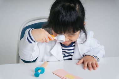 Yakışıklı Asyalı Taylandlı çocuk büyüteç kullanarak dişçilik yapıyor..