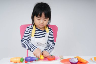 Güzel Asyalı Taylandlı çocuk mutfakta aşçılık yapıyor..
