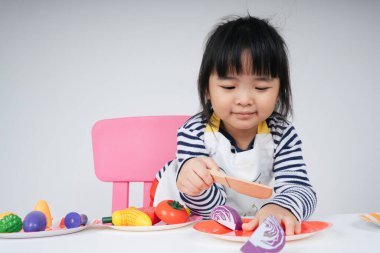 Güzel Asyalı Taylandlı çocuk mutfakta aşçılık yapıyor..