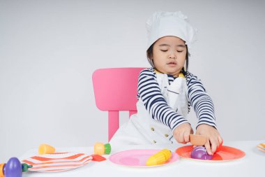Güzel Asyalı Taylandlı çocuk mutfakta aşçılık yapıyor..