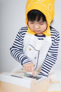 Güzel Asyalı Taylandlı çocuk, kasiyerde hesap makinesi kullanarak garsonluk yapıyor..