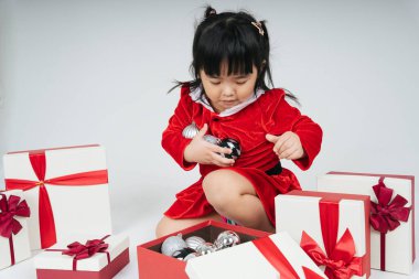 Noel Baba üniformalı, kar festivalini kutlamak için hediye kutulu güzel Asyalı çocuk..