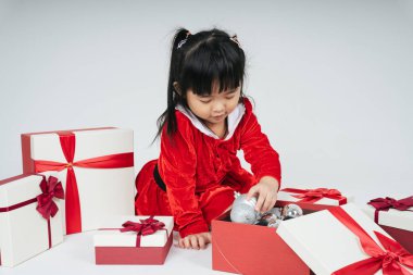 Noel Baba üniformalı, kar festivalini kutlamak için hediye kutulu güzel Asyalı çocuk..