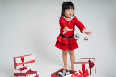 Noel Baba üniformalı, kar festivalini kutlamak için hediye kutulu güzel Asyalı çocuk..