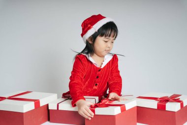 Noel Baba üniformalı, kar festivalini kutlamak için hediye kutulu güzel Asyalı çocuk..