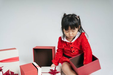 Noel Baba üniformalı, kar festivalini kutlamak için hediye kutulu güzel Asyalı çocuk..