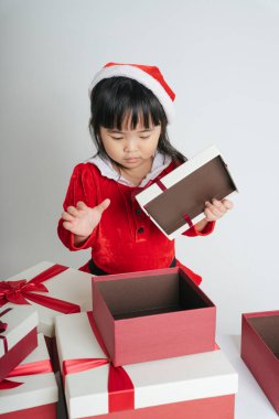 Noel Baba üniformalı, kar festivalini kutlamak için hediye kutulu güzel Asyalı çocuk..