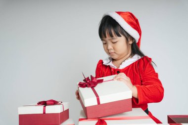 Noel Baba üniformalı, kar festivalini kutlamak için hediye kutulu güzel Asyalı çocuk..