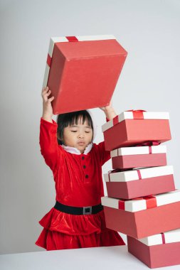 Noel Baba üniformalı, kar festivalini kutlamak için hediye kutulu güzel Asyalı çocuk..