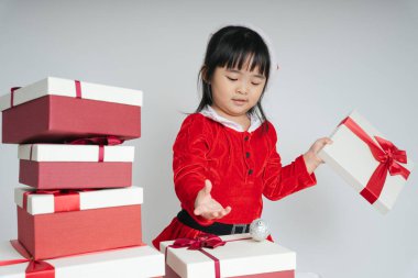 Noel Baba üniformalı, kar festivalini kutlamak için hediye kutulu güzel Asyalı çocuk..