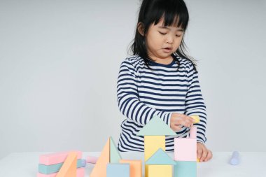 Güzel Asyalı Taylandlı kadın oyuncak blok şekliyle oynuyor..