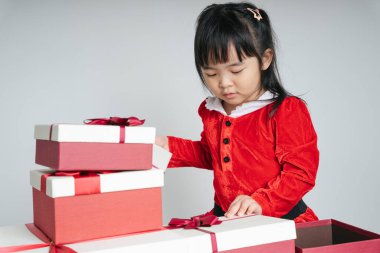 Noel Baba üniformalı, kar festivalini kutlamak için hediye kutulu güzel Asyalı çocuk..