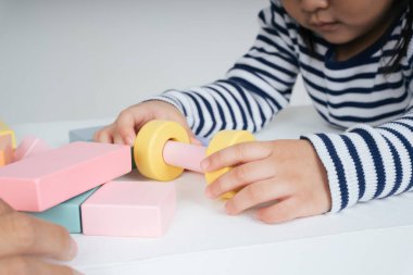 Güzel Asyalı Taylandlı kadın evde oyuncak bloğuyla oynuyor..