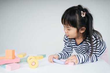 Güzel Asyalı Taylandlı kadın evde oyuncak bloğuyla oynuyor..