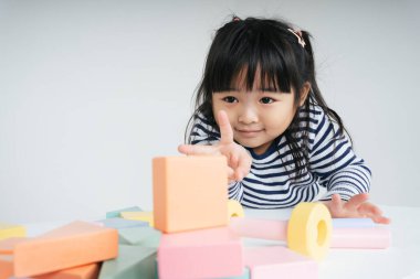 Güzel Asyalı Taylandlı kadın evde oyuncak bloğuyla oynuyor..