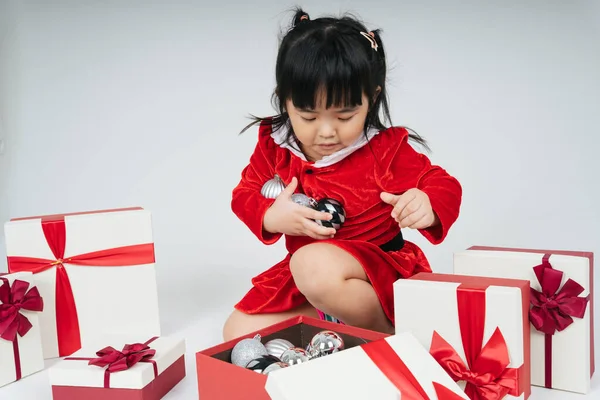 Noel Baba üniformalı, kar festivalini kutlamak için hediye kutulu güzel Asyalı çocuk..