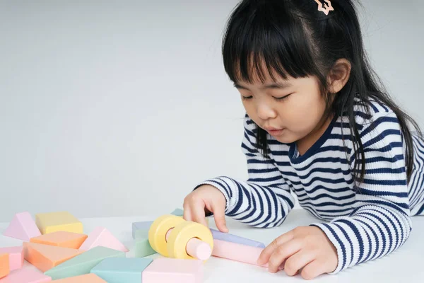 Güzel Asyalı Taylandlı kadın evde oyuncak bloğuyla oynuyor..