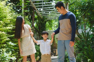 Asyalı Taylandlı bir aile okula giderken el ele tutuşuyor..