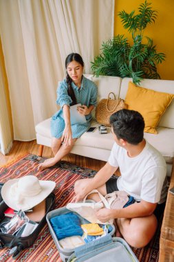 Seyahate çıkmadan önce Asyalı Taylandlı aile bavullarını bavula dolduruyor..