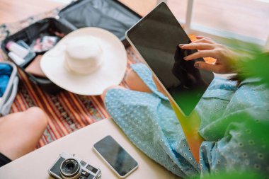 Dijital tabletle otel rezervasyonu yapan kadın.