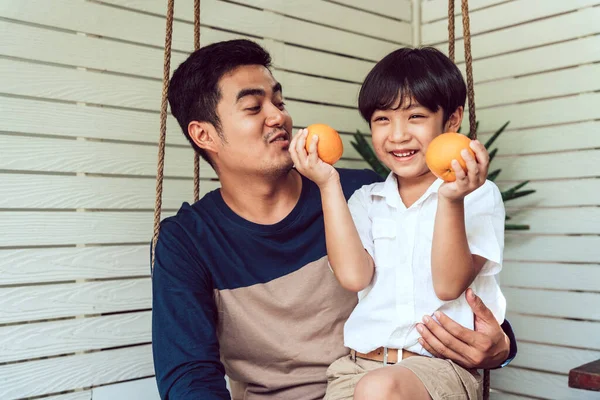 Ασιάτης Πατέρας Και Γιος Απολαμβάνουν Τρώνε Πορτοκαλί Φρούτα Για Πρωινό — Φωτογραφία Αρχείου
