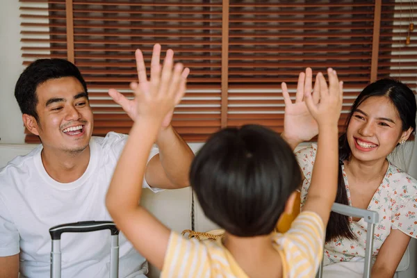 Back view - Asian thai family doing high five with their son to say good bye. Study abroad.