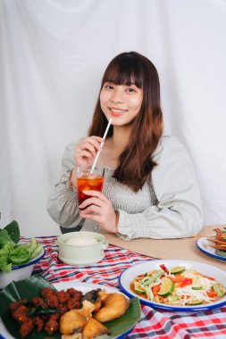 Isan yemeğiyle Tayland çayı içen Asyalı kadının portresi..